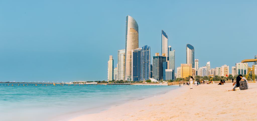 Luxury Abu Dhabi Corniche yacht charter beach with skyline and clear turquoise water