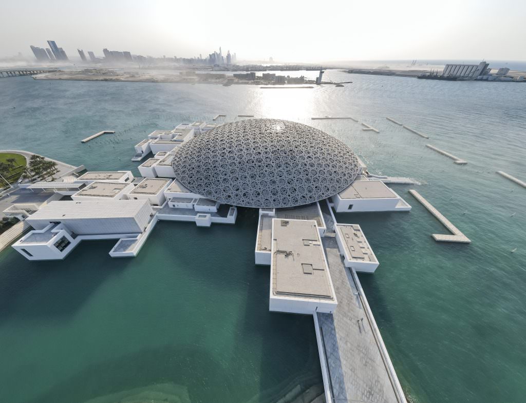 Luxury Abu Dhabi yacht charter view of Louvre Museum aerial architecture over turquoise sea