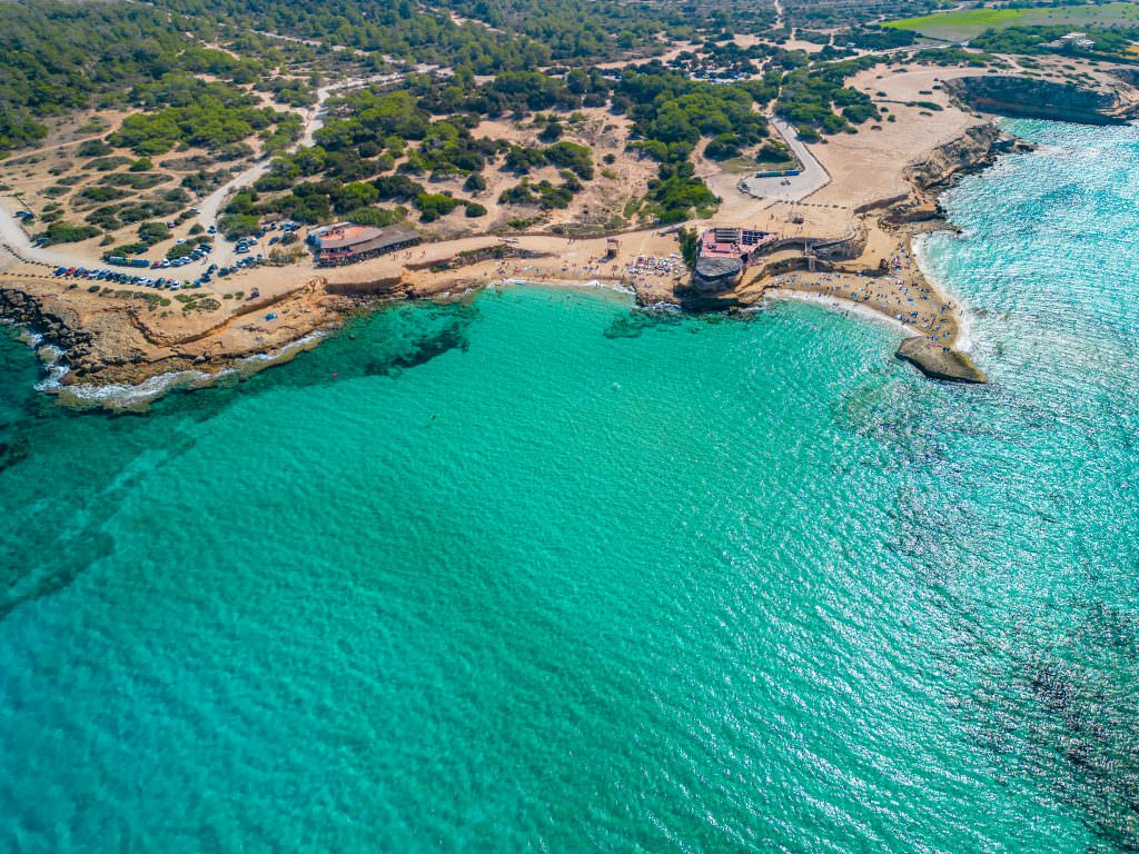 Turquoise water Cala Comte beach Ibiza aerial Mediterranean yacht anchorage
