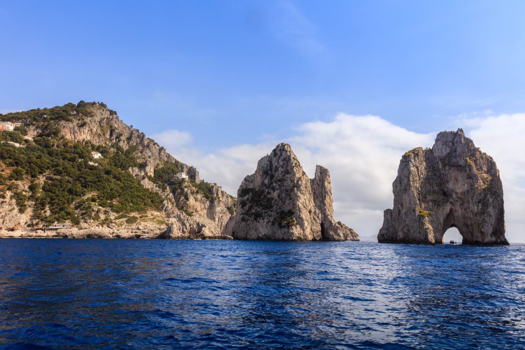 Capri yacht charter luxury Mediterranean cliffs Faraglioni rocks Italy view