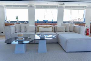 De Love motor sailer main salon seating area with panoramic windows, luxury yacht charter interior lounge with elegant design and natural light