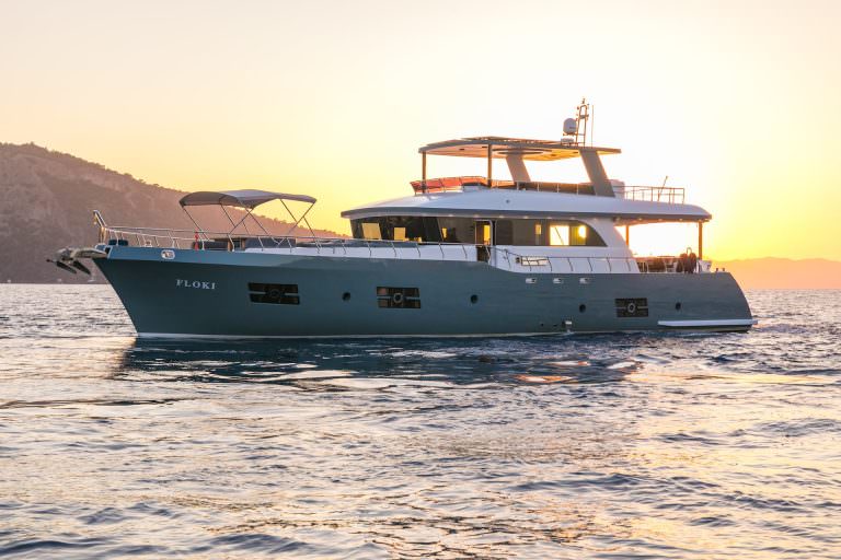 Floki yacht charter luxury yacht cruising at sunset, exclusive yacht charter experience with golden hour sea views