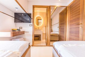 Floki luxury yacht charter twin cabin with two single beds, modern interior and direct ensuite bathroom access