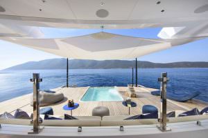 Legasea luxury yacht aft deck pool with sunbeds, shaded canopy and panoramic sea view