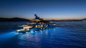 Legasea superyacht cruising at sunset with underwater lights, ultra luxury yacht charter experience at sea