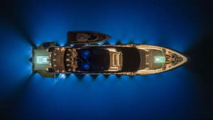 Legasea luxury yacht top view at night with illuminated deck and underwater blue lighting