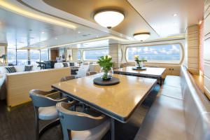Luxury yacht MOCA dining area with elegant table setting and panoramic sea view windows
