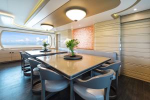 Luxury yacht MOCA dining area with modern table design, elegant seating and sea view window