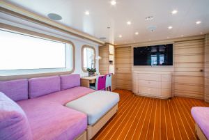 Luxury yacht MOCA guest cabin with lounge seating, TV and modern interior design