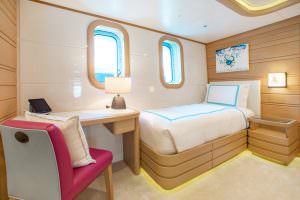 Luxury yacht MOCA guest cabin with single bed and desk area