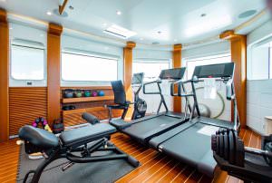Luxury yacht MOCA onboard gym with treadmill, weights and modern fitness equipment
