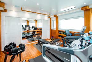 Luxury yacht MOCA onboard gym with treadmill, weights and modern fitness equipment