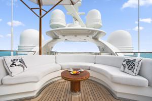 Luxury yacht MOCA sundeck lounge with curved seating, table and open sea view