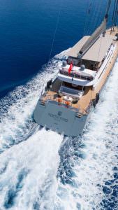 North Wind motor sailer aft deck view, luxury yacht cruising with panoramic sea wake, elegant outdoor space and premium charter experience