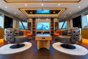 North Wind motor sailer salon entertainment lounge, ultra luxury yacht interior with designer armchairs, ambient lighting and premium media setup