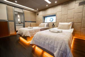 North Wind motor sailer twin cabin interior, luxury yacht bedroom with twin beds, soft ambient lighting, modern wall design and premium comfort details