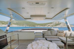 Reis yacht flybridge lounge with panoramic sea view and seating area, luxury yacht charter experience