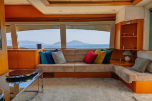Reis yacht salon with panoramic sea view, comfortable seating area and elegant wooden interior, luxury yacht charter experience