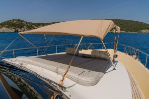 Reis yacht sunbathing deck with comfortable loungers, canopy shade and stunning sea view, luxury yacht charter experience