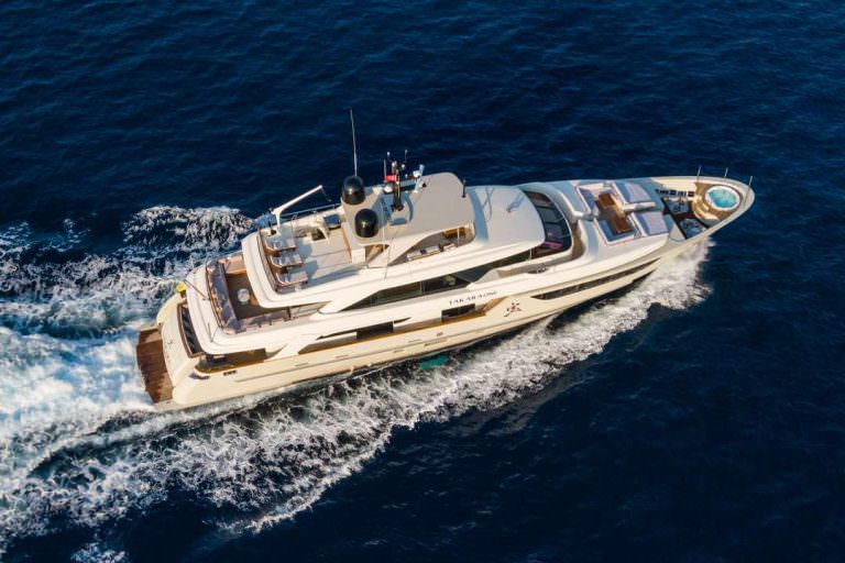 Takara One yacht charter aerial view cruising on deep blue sea with wake trail